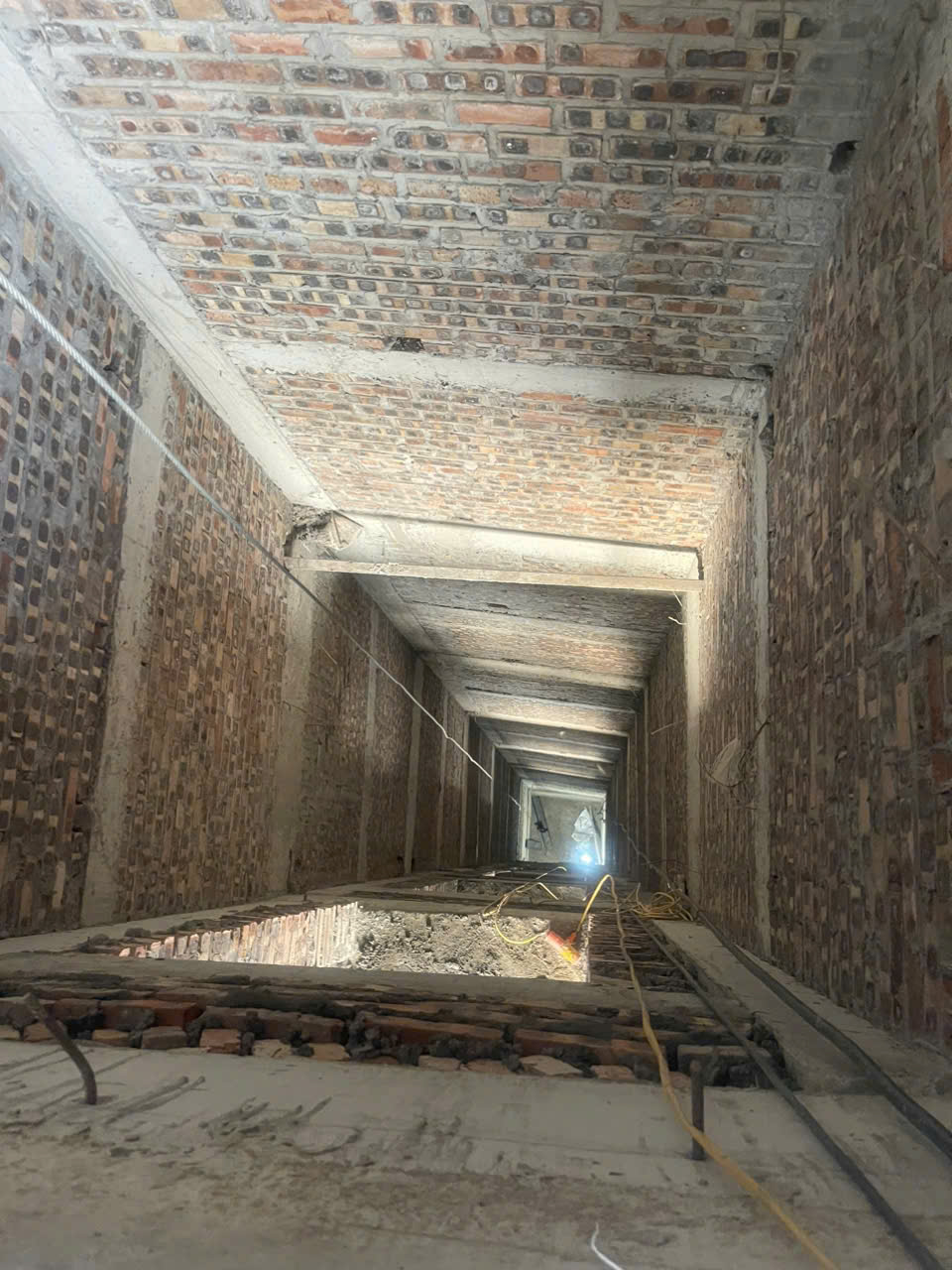 Hố thang máy đang thi công với tường gạch 